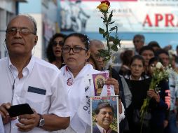 Una mujer con una foto del expresidente Alan Garía aguarda este viernes para entrar al local del partido donde se realiza el funeral en Lima, Perú. AP/M. Mejía