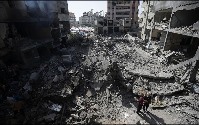 Palestinos revisan la destrucción causada por un bombardeo israelí en el campo de refugiados de Nuseirat. AP/Jehad Alshrafi/archivo