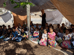 Niños palestinos estudiando en una escuela improvisada, luego de quedarse sin hogar. EFE/H. IMAD